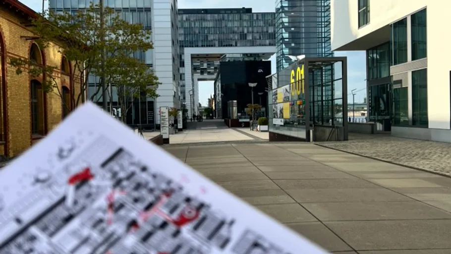 Map held in hand, modern buildings in background.