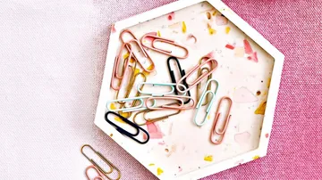 Colorful paper clips on decorative tray.