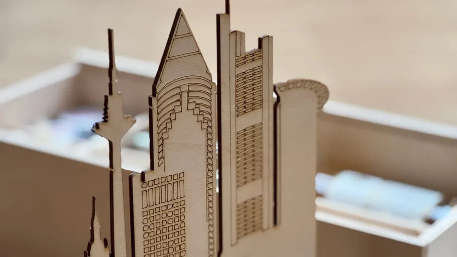 Wooden skyscraper model with detailed engravings.