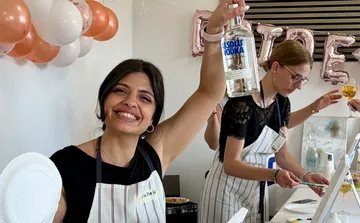 Lächelnde Frau hält Wodkaflasche bei Party.