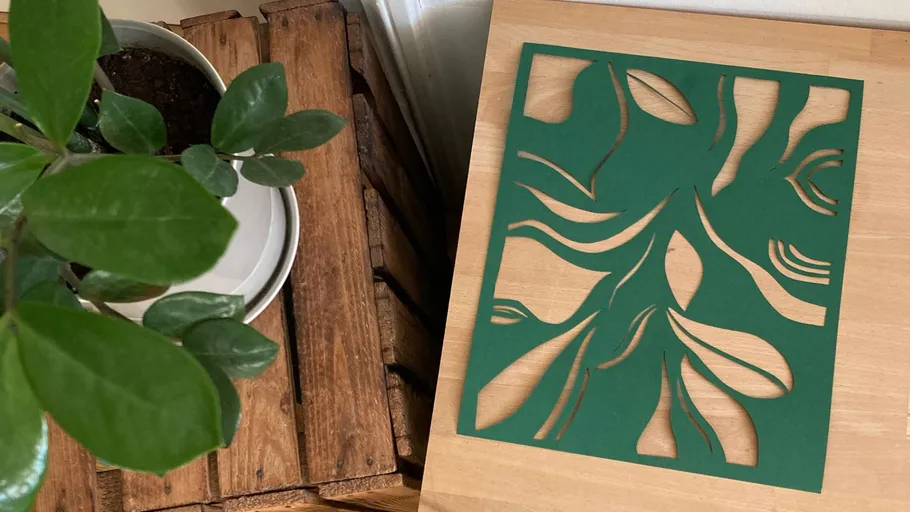 Leafy plant next to green abstract art.