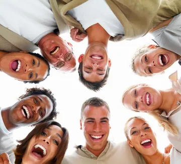 Group of people smiling in circle formation.
