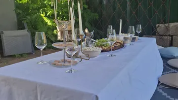Eleganter Picknicktisch mit Snacks und Kerzen im Freien.