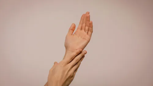 Hands touching against a plain background.