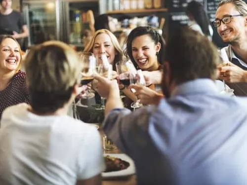 Freunde stoßen mit Weingläsern in einem Restaurant an.