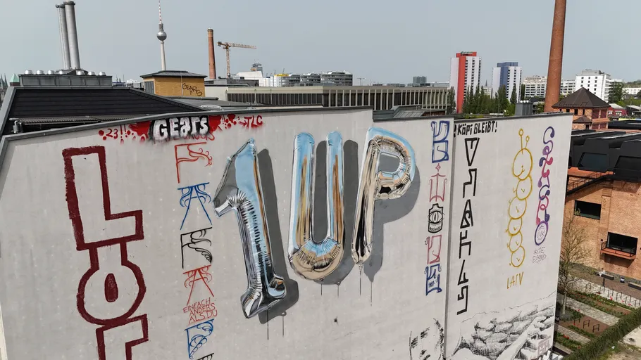 Graffiti mural on urban rooftop, Berlin skyline.