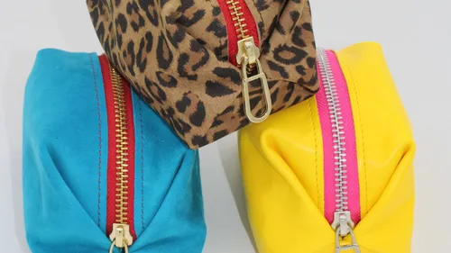 Three colorful zippered pouches stacked together.