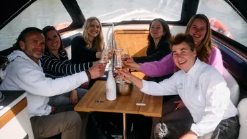 People toasting on a boat interior.
