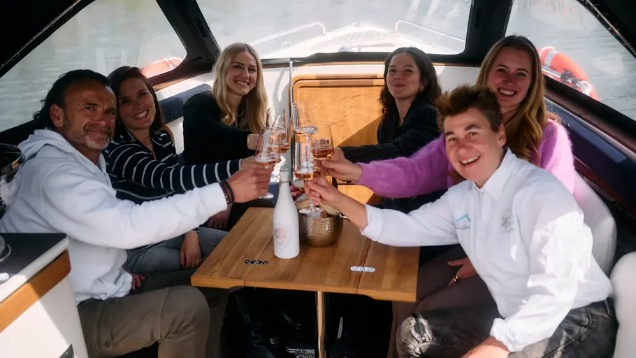 People toasting on a boat interior.