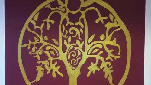 Goldene Baum-Silhouette auf rotem Hintergrund.