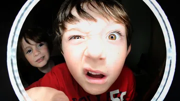 Two boys making faces inside a circular frame.