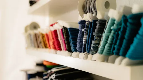Colorful reels of thread on shelves.