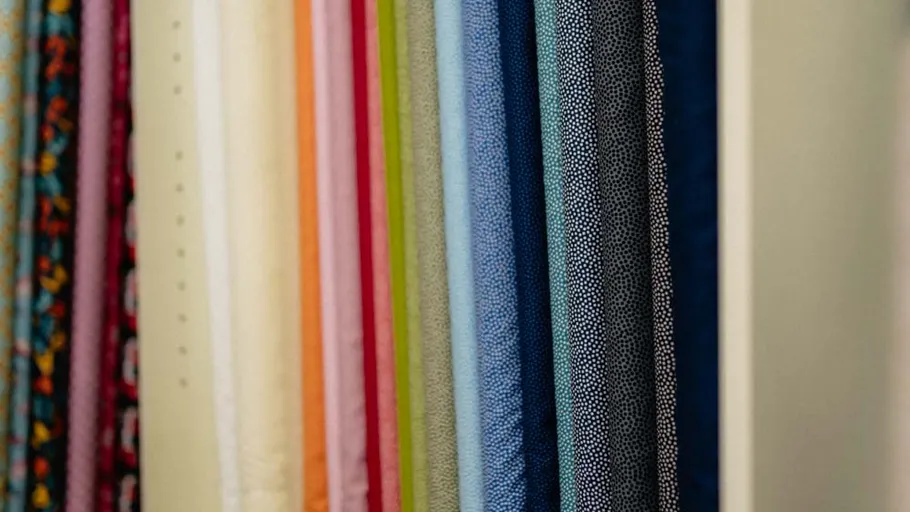 Bunte Stoffrollen in einem Ladenregal.