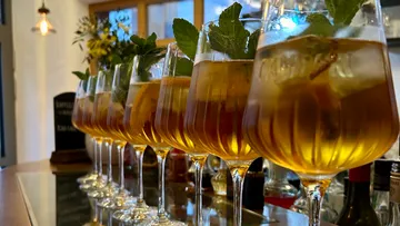 Glasses with iced drink and mint on bar.