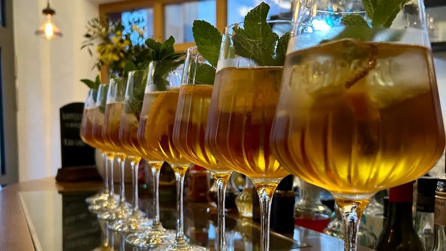 Gläser mit Eisgetränk und Minze an Bar.