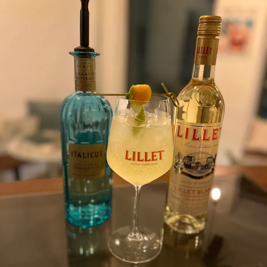 Cocktailglas mit Lillet- und Italicus-Flaschen.