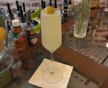 Cocktail on bar counter with garnish.