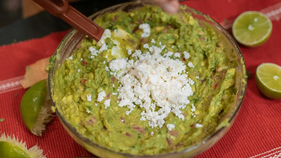 Guacamole mit Käse in einer Glasschüssel.