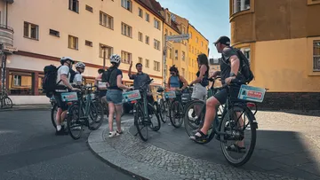 Group of cyclists stopping on urban street.