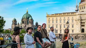 Gruppe mit Fahrrädern, Berliner Dom im Hintergrund.