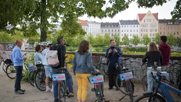 Gruppe mit Fahrrädern, hört einem Führer zu.