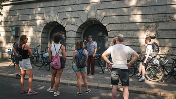 Group listening to guide near stone building.