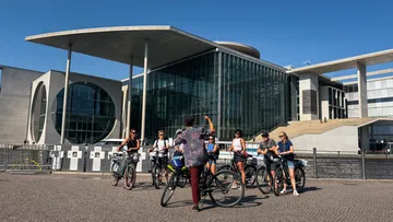 Gruppe von Radfahrern vor einem modernen Gebäude.