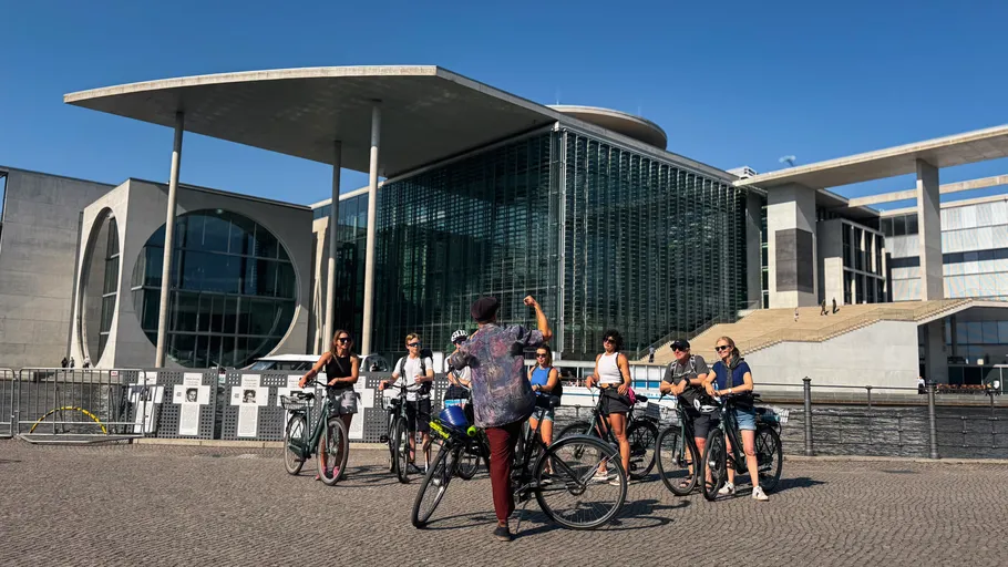 Group of cyclists outside a modern building.