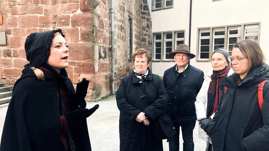 Führer spricht zu Gruppe im historischen Innenhof.