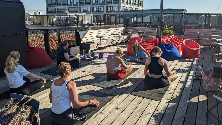 Women practicing yoga on a rooftop terrace.