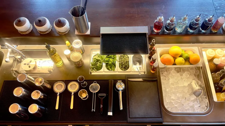 Bar countertop with tools and ingredients organized.