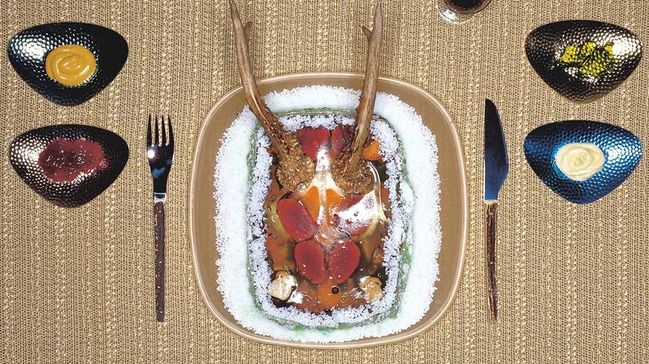 Decorative food platter with antlers on textured table.