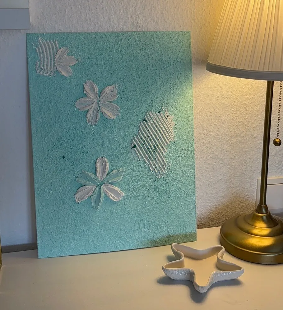 Texturierte Kunstleinwand neben beleuchteter Lampe.