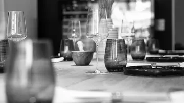 Wine glasses on elegantly set restaurant table.