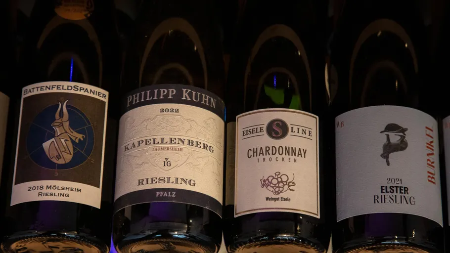 Four wine bottles on a shelf.