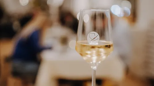 Wine glass on table in restaurant setting.