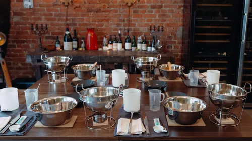 Metal bowls on table in brick-walled room.