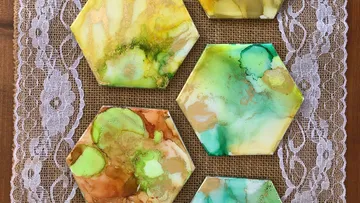 Colorful hexagonal coasters on lace-bordered burlap.