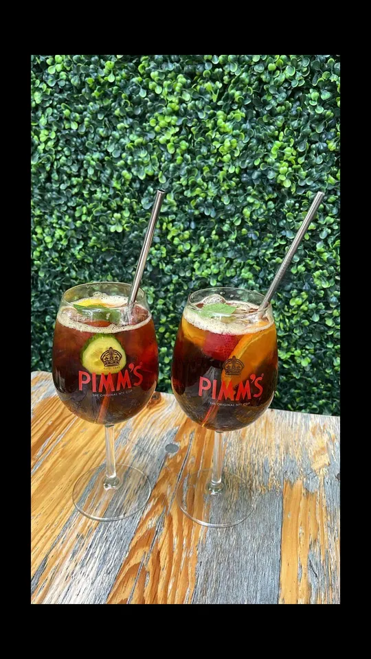Zwei Pimm's Cocktails auf Holztisch.