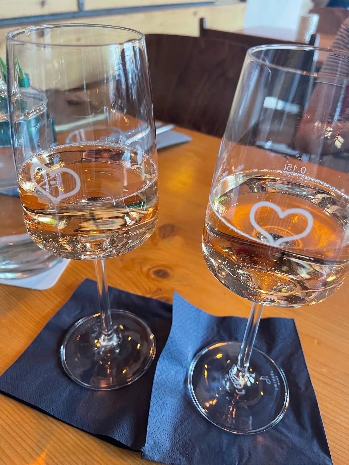 Zwei Weingläser auf einem Holztisch.