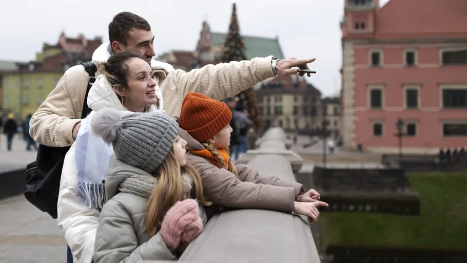 Familie zeigt interessiert, Stadtansicht im Hintergrund.