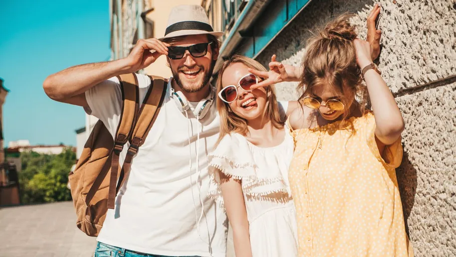 Three friends posing outdoors, smiling brightly.