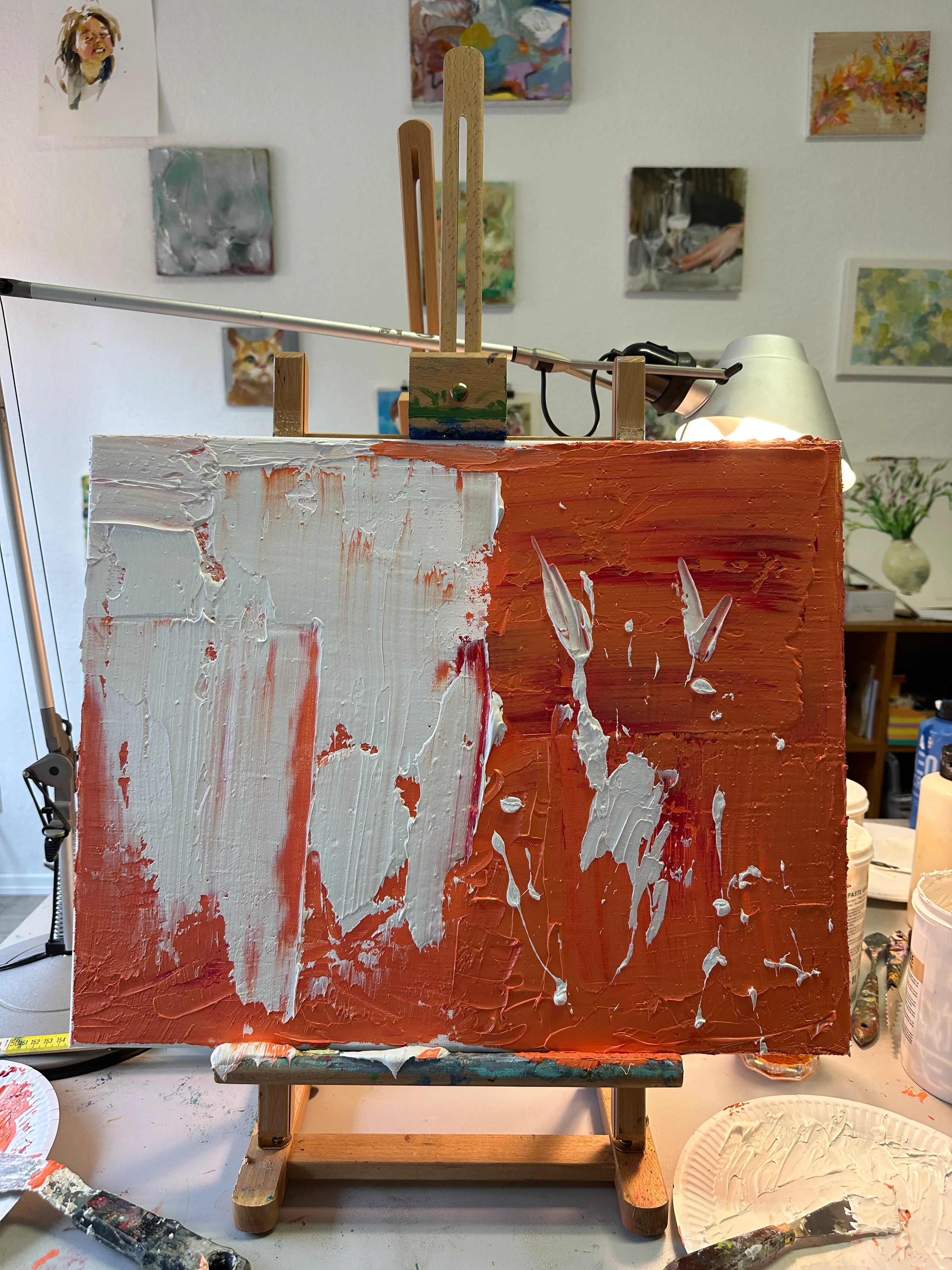 Gemälde auf Staffelei mit abstraktem Rot und Weiß.