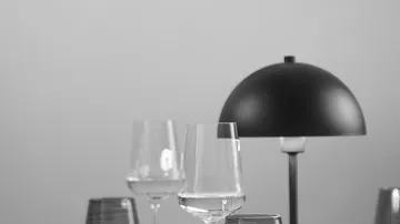 Wine glasses and lamp on a table.