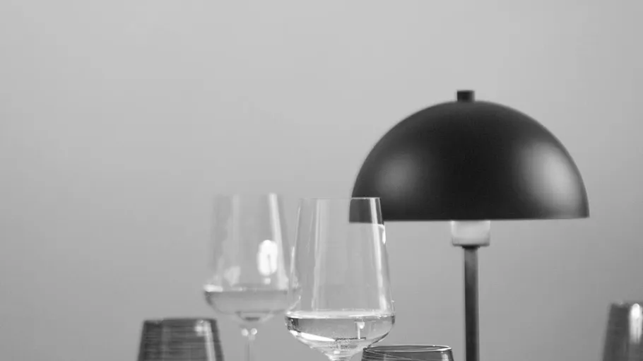Weingläser und Lampe auf einem Tisch.