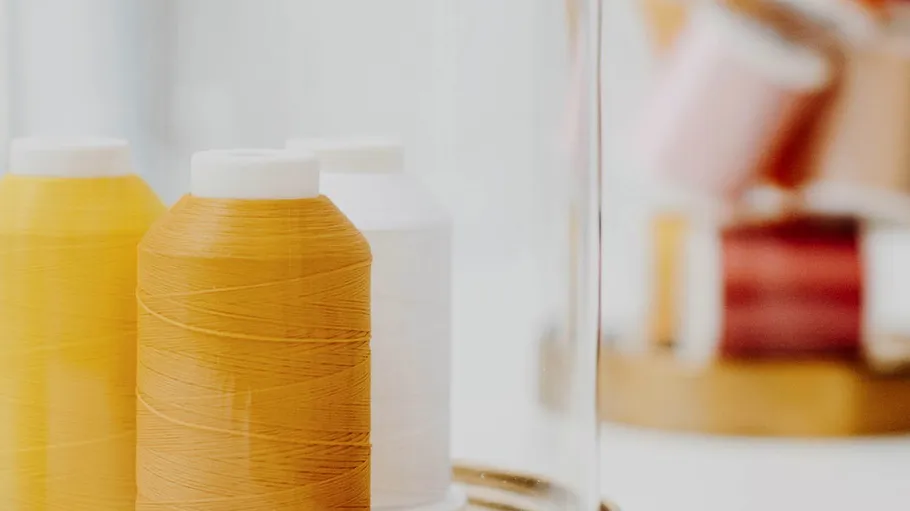 Colorful thread spools on a white table.