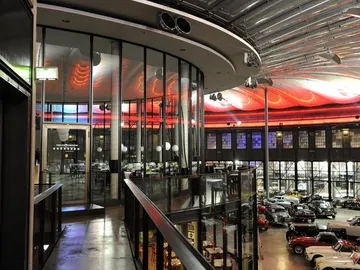 Ein modernes Restaurant über einem Ausstellungsraum mit Autos.