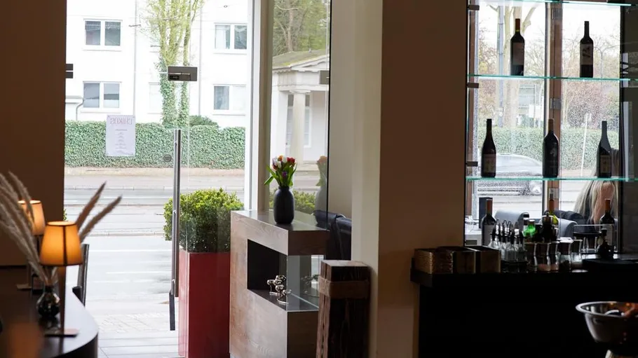Restaurant interior with glass door and shelves.