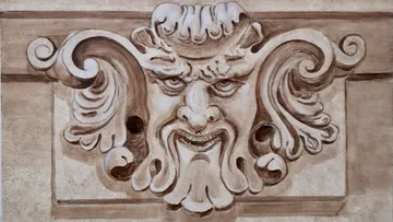 Ornate stone carving of a mythical face.