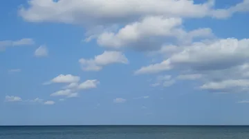 Ocean view with clouds and blue sky.
